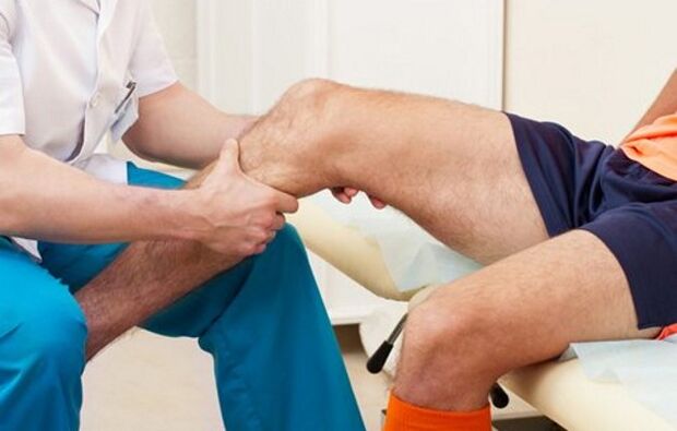 The doctor checks the knee for joint disease